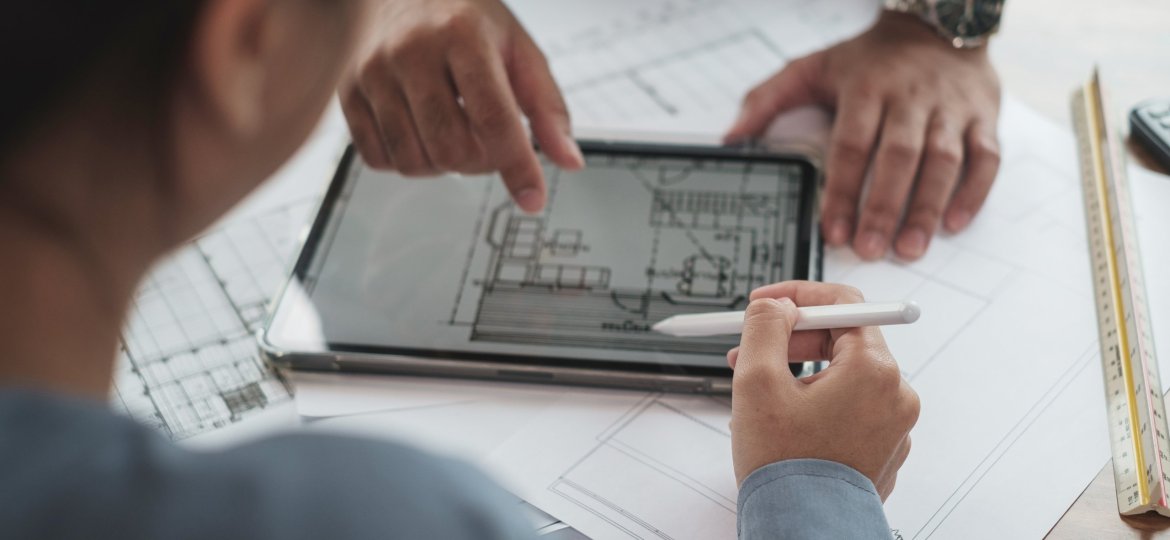 Architect or Engineer team designer discussing detail drawing on digital tablet.